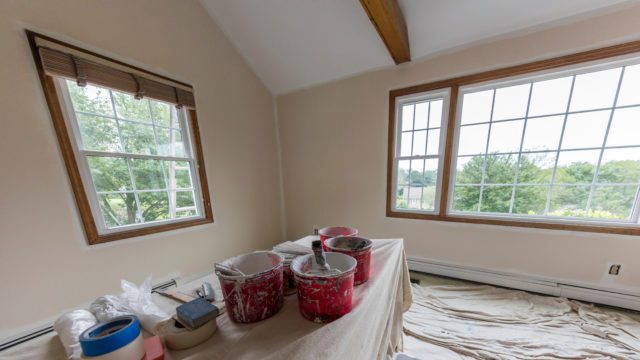 The interior of a home is prepped for paint, and paint supplies are laid out for use
